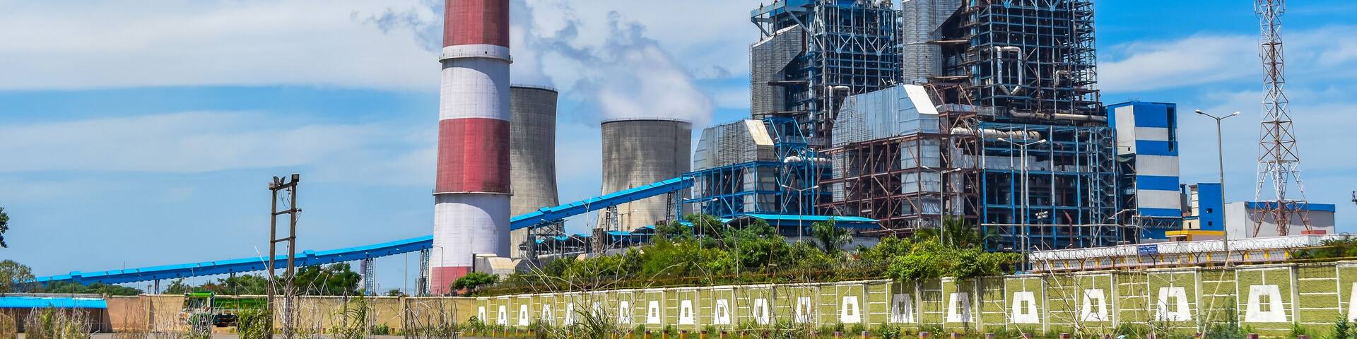 the chimneys of the thermal power station with white clouds of steam and Cooling tower of thermal power plant at neyveli, India