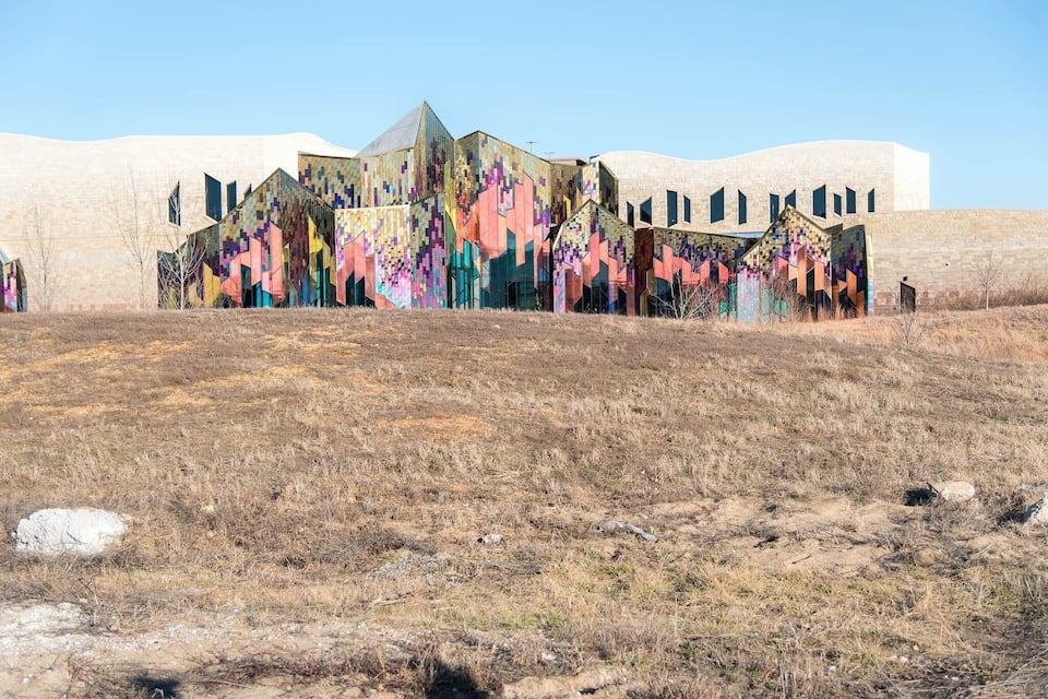 A building with colorful geometric patterns and a barren landscape.