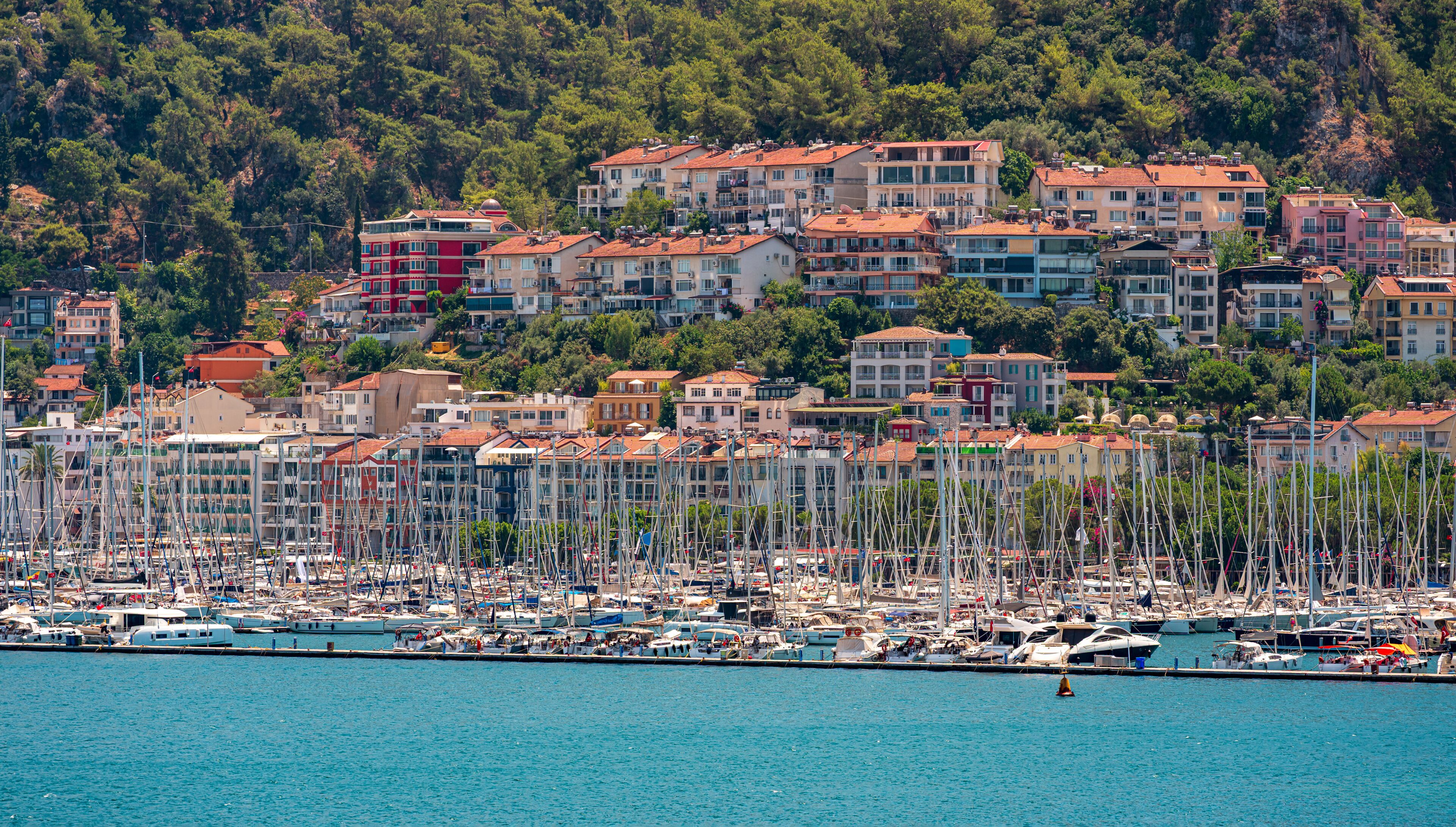 Panoramic view of colorful beach houses and a marina filled with yachts in Fethiye, Turkey