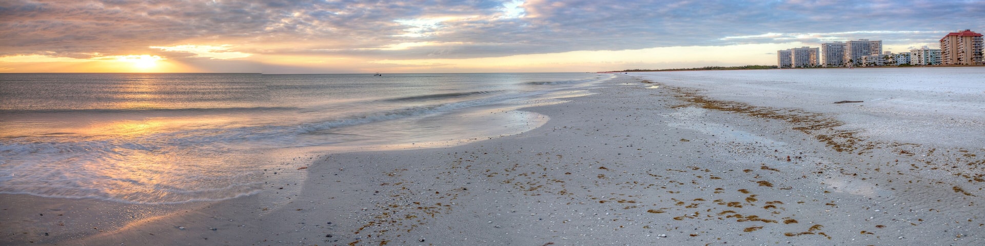 Sunset and clouds over the calm water of Tigertail Beach on Marco Island