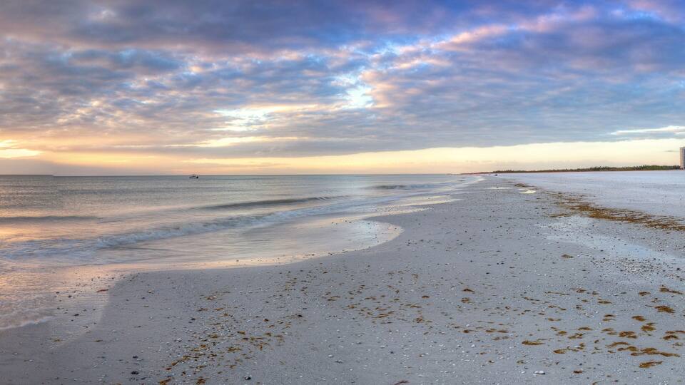 Sunset and clouds over the calm water of Tigertail Beach on Marco Island