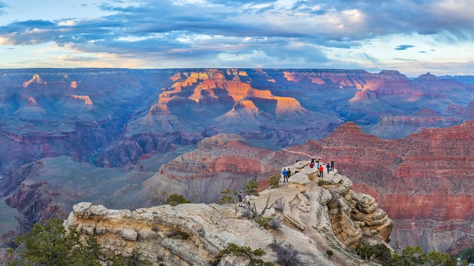 People admire the incredible sunset views of Grand Canyon National Park, Northern Arizona, USA.