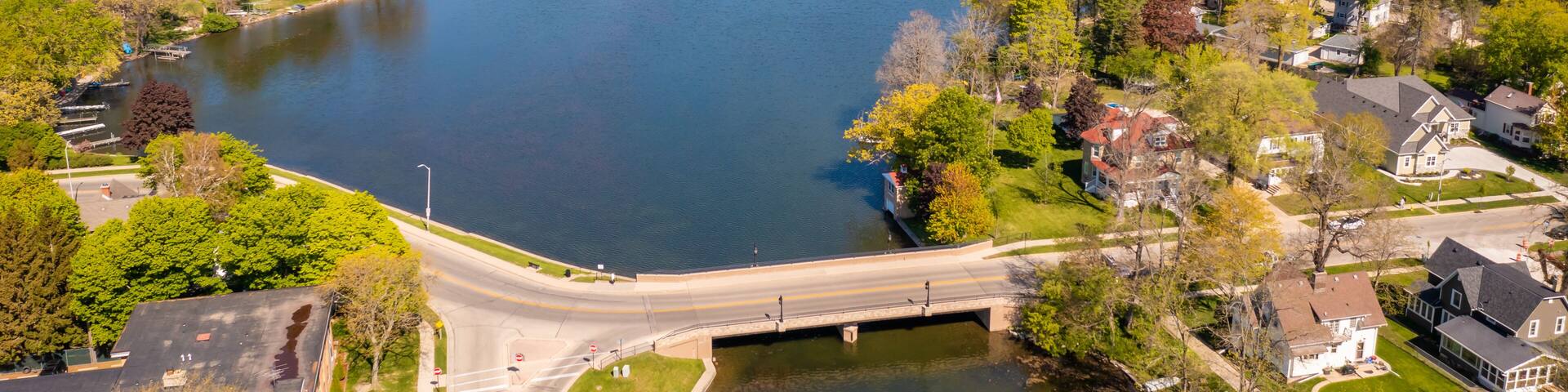 Aerial view of Oconomowoc Lake and surrounding residential and commercial buildings