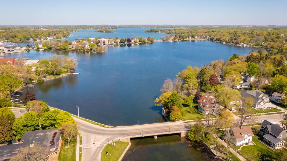 Aerial view of Oconomowoc Lake and surrounding residential and commercial buildings
