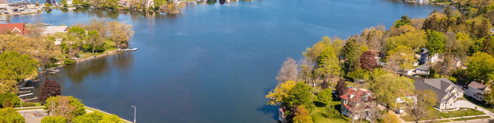 Aerial view of Oconomowoc Lake and surrounding residential and commercial buildings