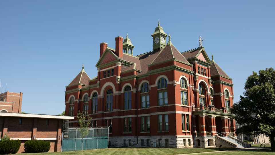 A large red brick building with arched windows and a clock tower.