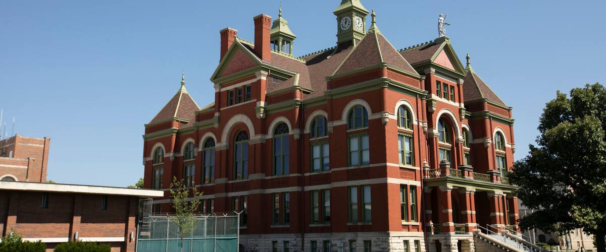 A large red brick building with arched windows and a clock tower.