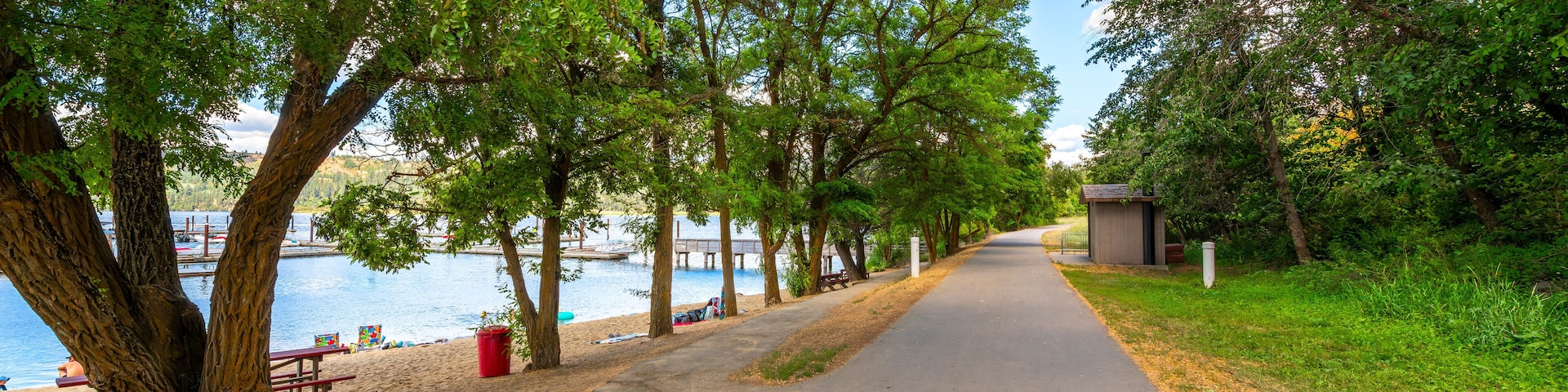 The Trail of the Coeur d'Alenes as it runs past a small sandy beach at the small lakeside town of Harrison, Idaho, USA, in the general Coeur d'Alene area of North Idaho.