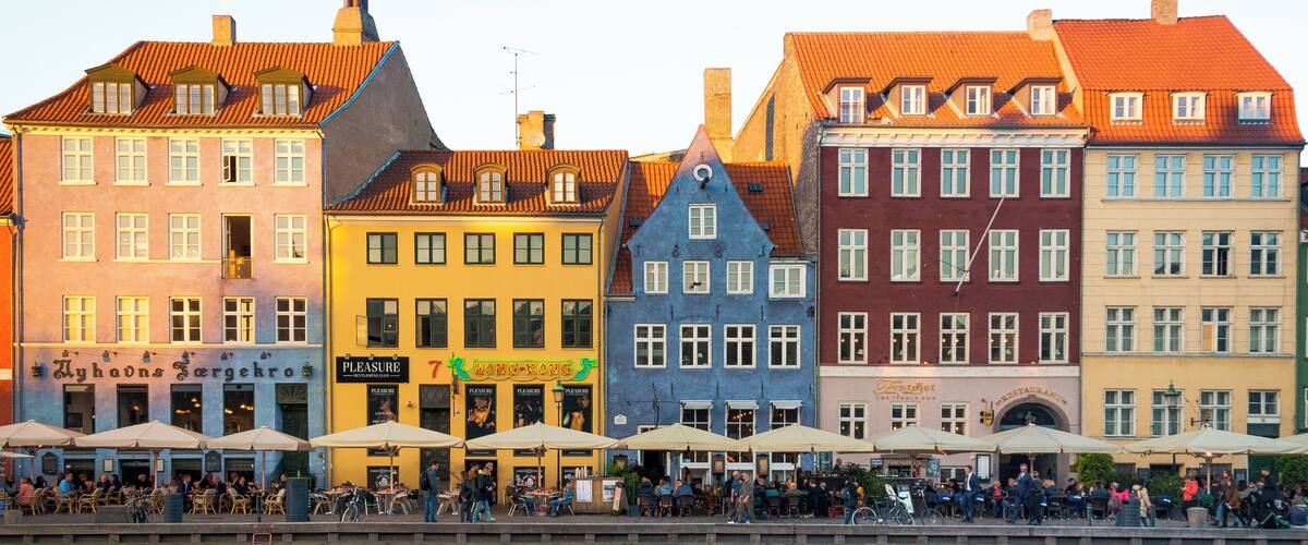 Nyhavn (New Harbour) is a 17th-century waterfront, canal and entertainment district in Copenhagen, Denmark. Stretching from Kongens Nytorv to the harbour front just south of the Royal Playhouse, it is lined by brightly coloured 17th and early 18th century townhouses and bars, cafes and restaurants. The canal harbours many historical wooden ships.