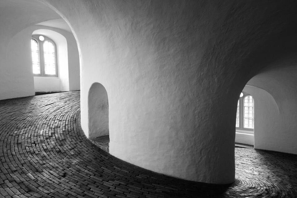 An interior with arched ceilings and a brick floor.