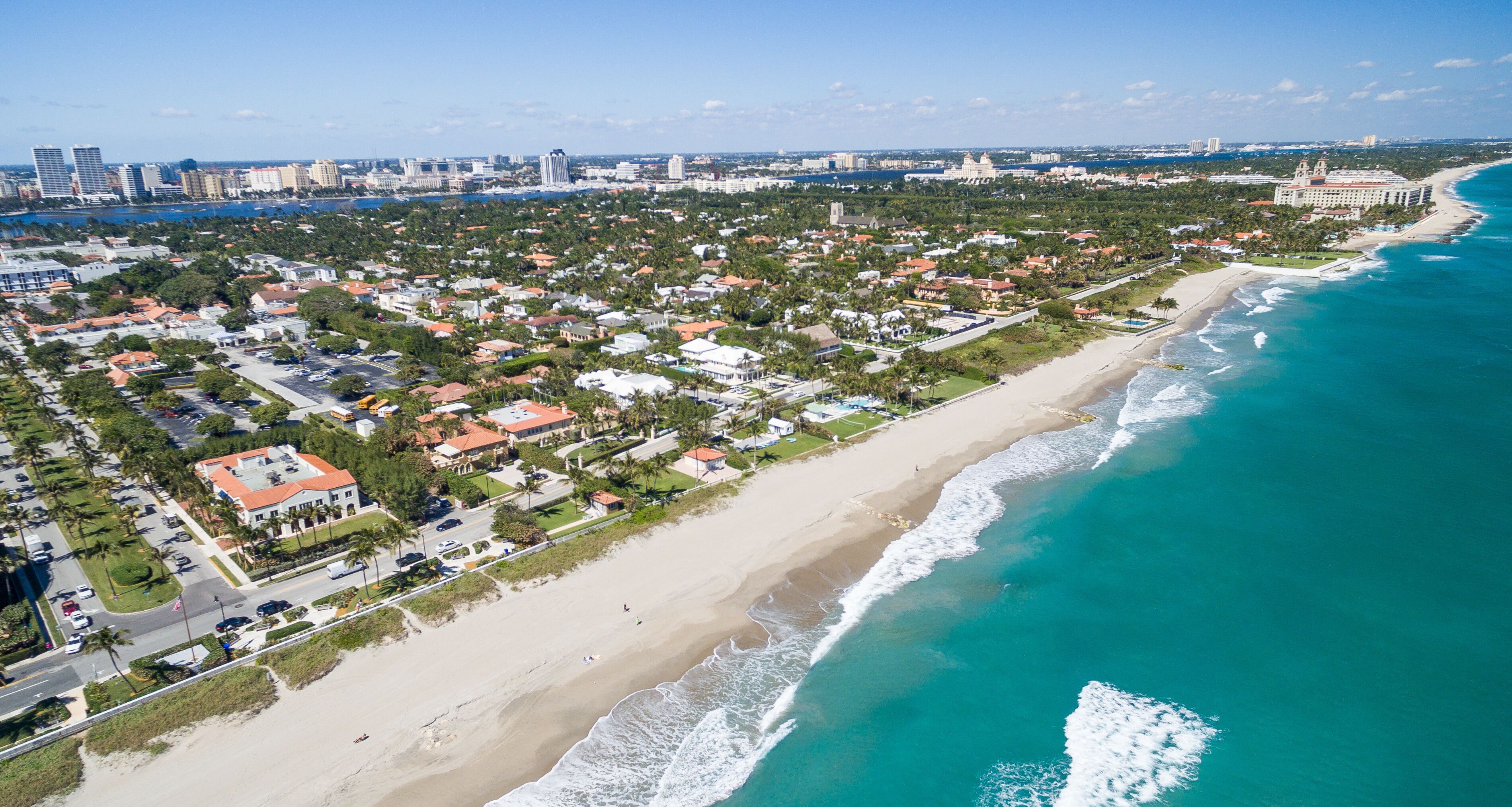 A coastal cityscape with a beach, residential areas, and a large hotel by the ocean.