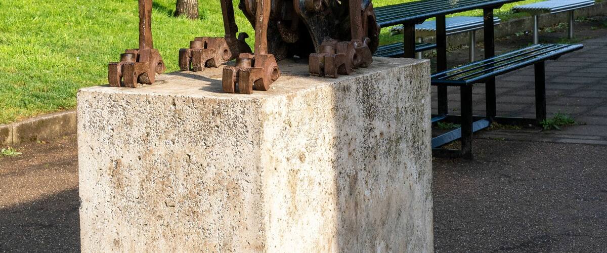 Vertical shot of a metal statue of a dog on a stone plinth in Blaise Castle Estate, Bristol