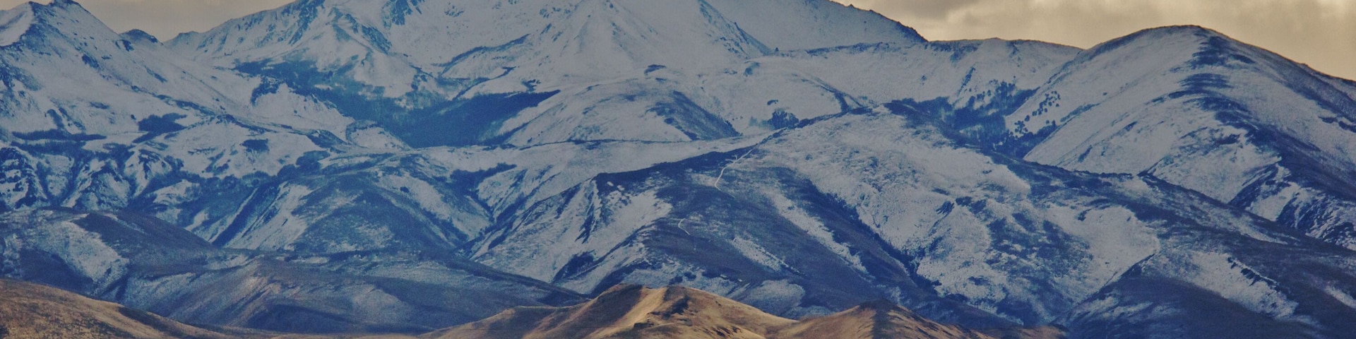 Unusual lighting showcase Snow capped McConnell Peak in shadow with sunlit foothills, Santa Rosa Mountains, Fort McDermitt area, Nevada