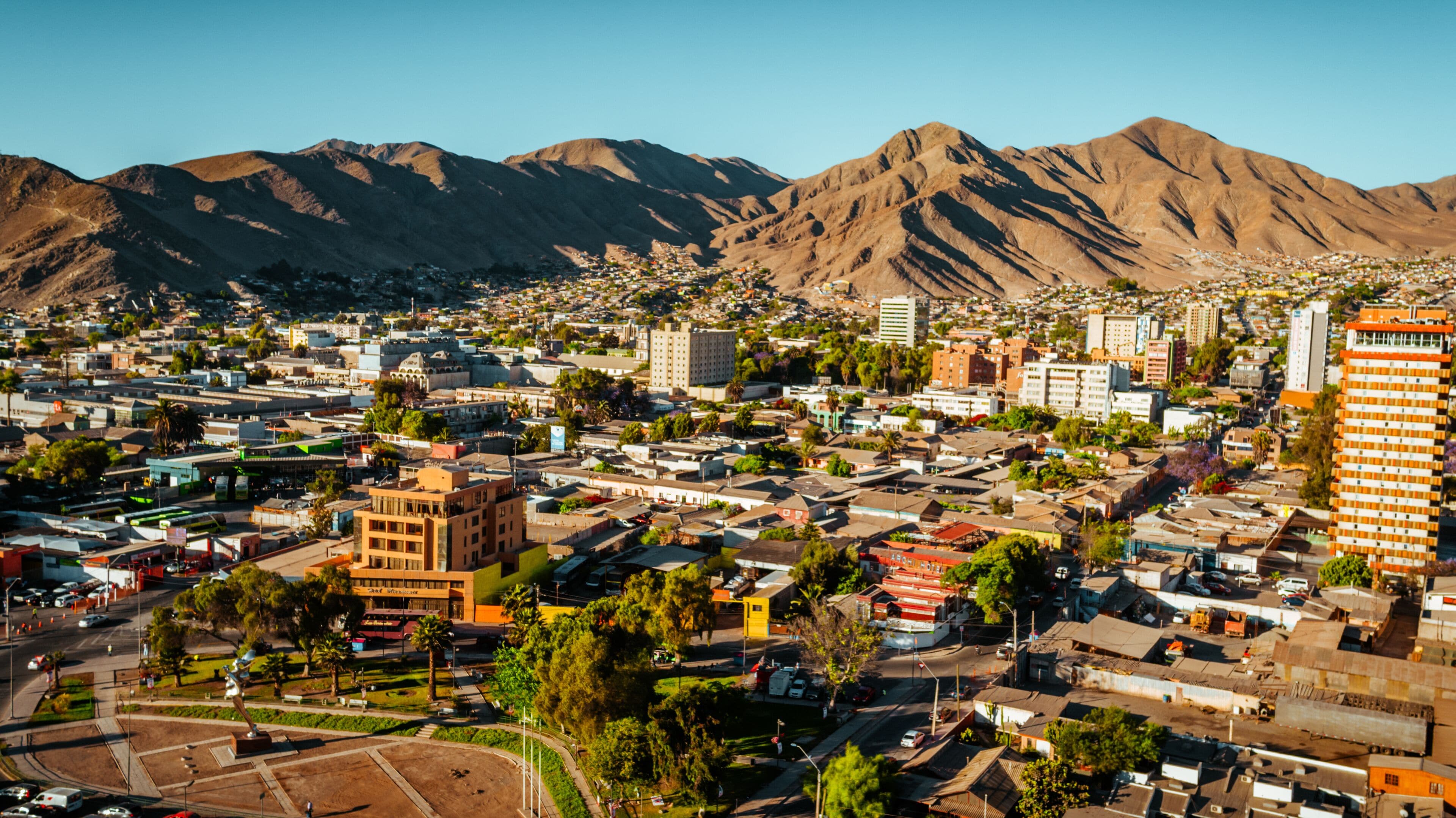 Un paisaje urbano con montañas al fondo.