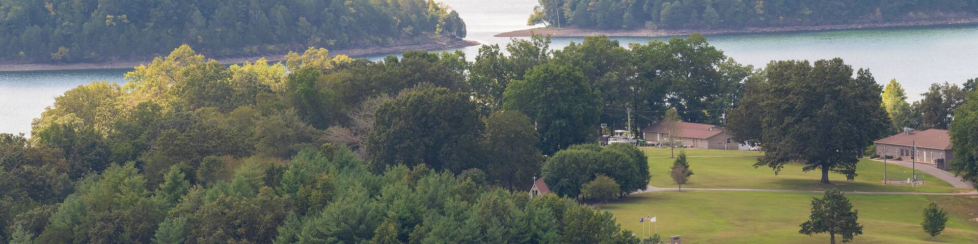 A lake surrounded by dense forests and a golf course.