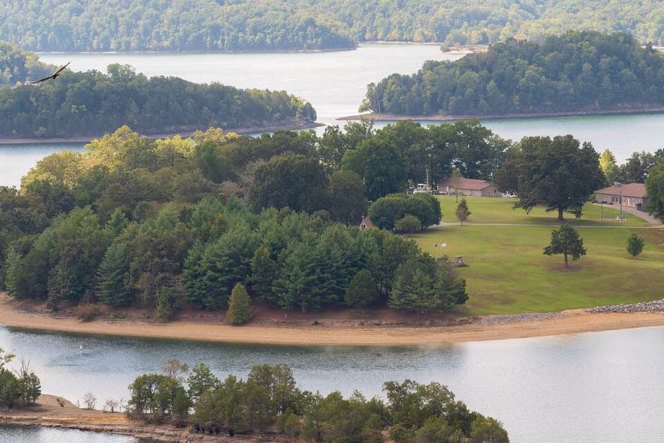 Um lago rodeado por florestas densas e um campo de golfe.