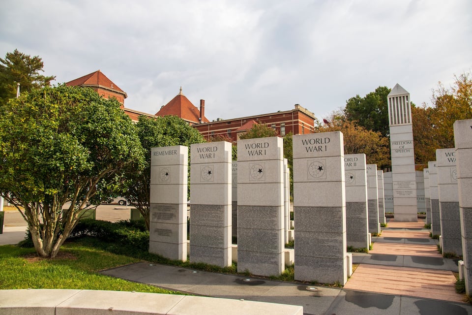 A row of World War II memorials with inscriptions and a Freedom of Speech monument.
