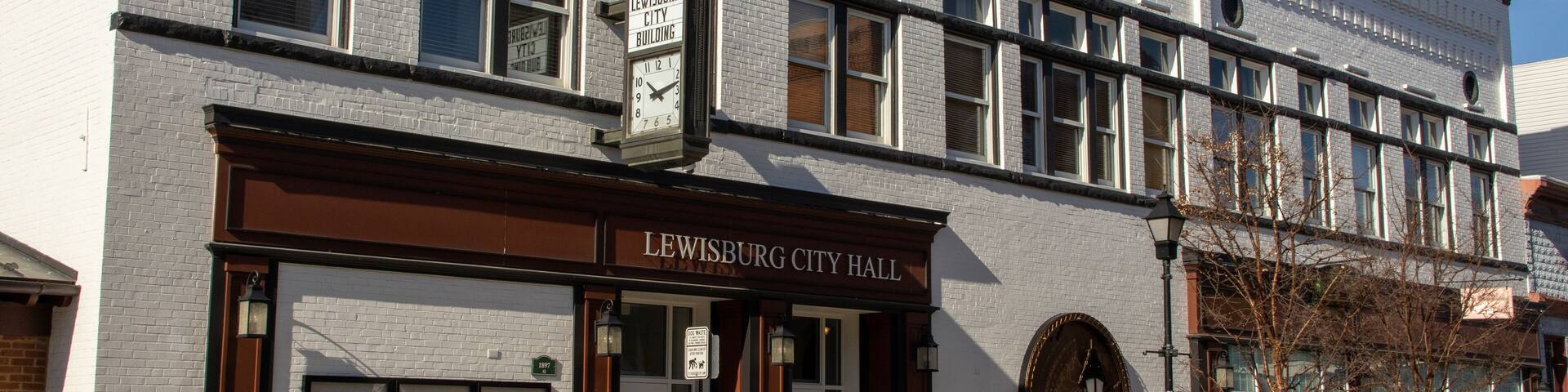 A historic building with a clock and the name "LEWISBURG CITY HALL".