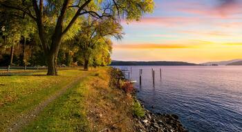 Autumn sunset view with fall colors on the leaves along the tree lined Centennial Trail path as it makes it's way along the lake near Silver Beach in Coeur d'Alene, Idaho USA.
