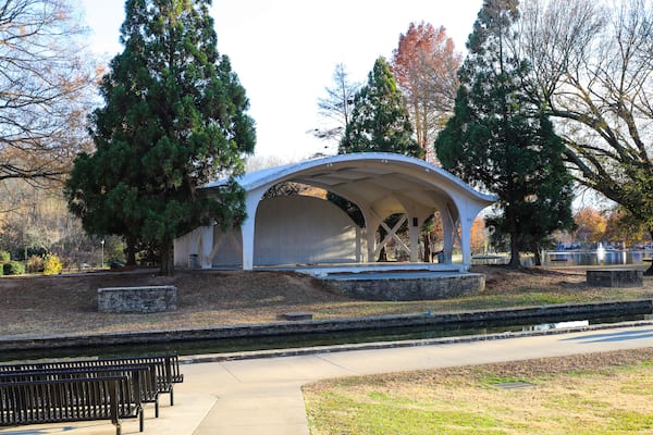a shot of a curvy white amphitheater in the park surrounded by gorgeous autumn colored trees near a lake with a long smooth winding footpath at Freedom Park in Charlotte North Carolina USA