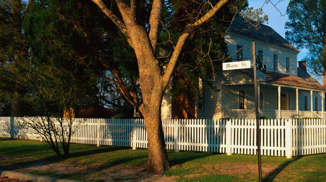 This is a photo of a typical suburban house on Main Street, USA. There is a white picket fence on a shaded, tree lined street with a green lawn. At the corner is a street sign that says, Main Street & Front Street. This is the Bonner House which was built in 1820. The town of Bath was founded in 1690.