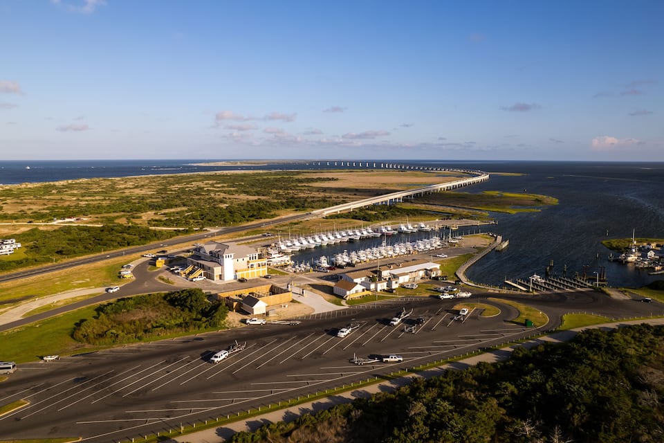 A coastal marina with boats, a bridge, and a highway.