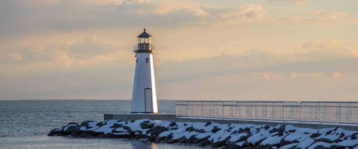 Sandspit Lighthouse and fishing pier in snow during winter, Patchogue Long Island New York