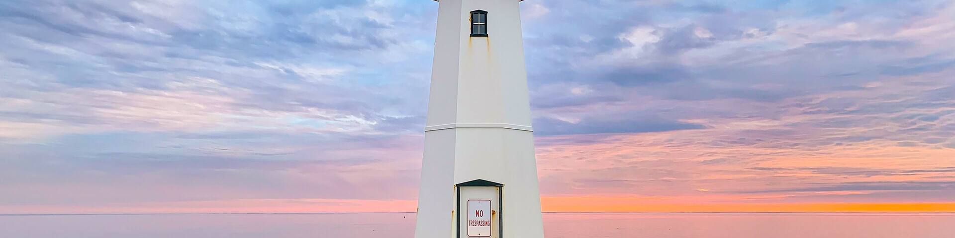 Sandspit Park Lighthouse and fishing pier in Patchogue New York, Long Island, with colorful sunset clouds and colors