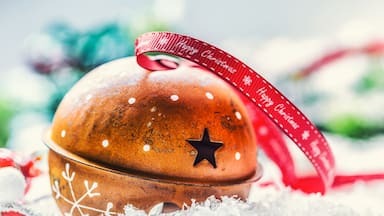 Christmas balls jingle bells. Red ribbon with text Happy Christmas. Snowy abstract background and decoration.