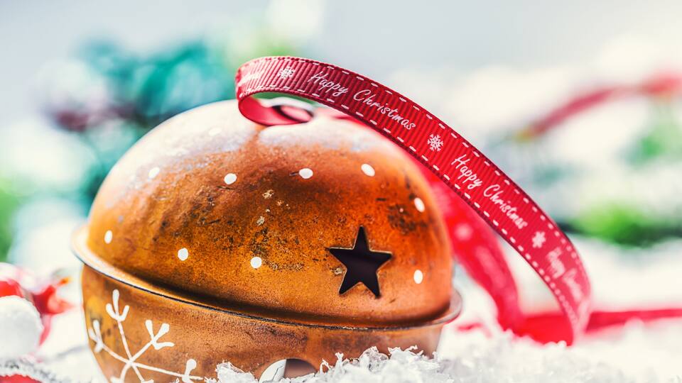 A Christmas bell with a red ribbon and star decoration.