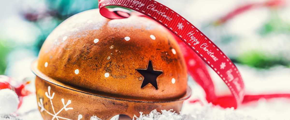 A Christmas bell with a red ribbon and star decoration.