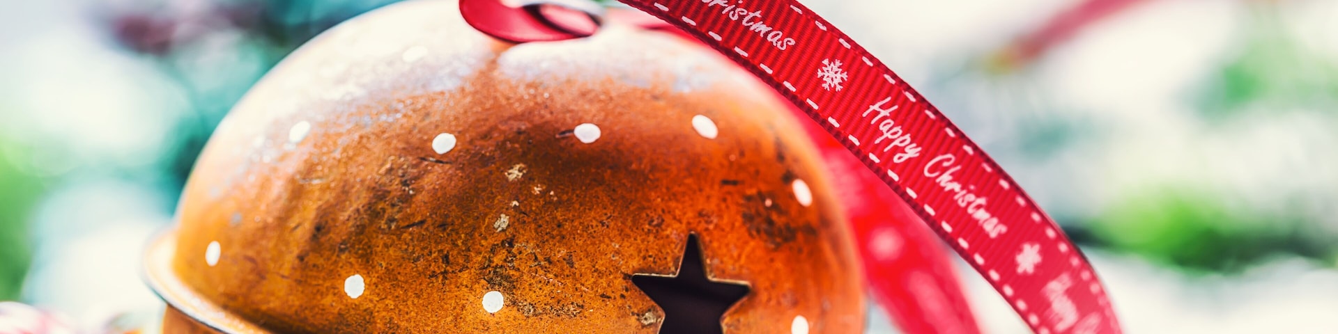 A Christmas bell with a red ribbon and star decoration.
