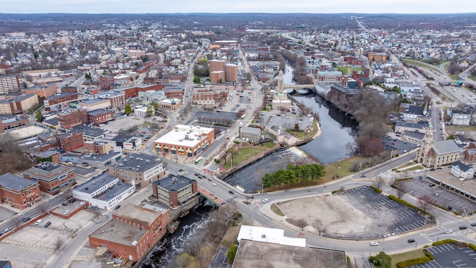 An aerial view of a city with a river, bridges, and a mix of historic and modern buildings.