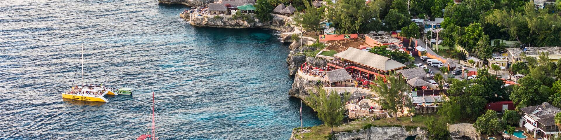 Negril, Jamaica, aerial landscape view of area around the famous Rick's Cafe in Negril, with boats near the cliff jumping spot and many people at the cliff