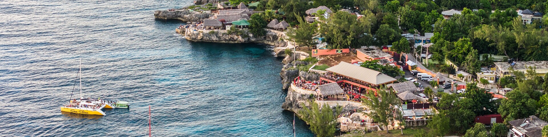 Negril, Jamaica, aerial landscape view of area around the famous Rick's Cafe in Negril, with boats near the cliff jumping spot and many people at the cliff