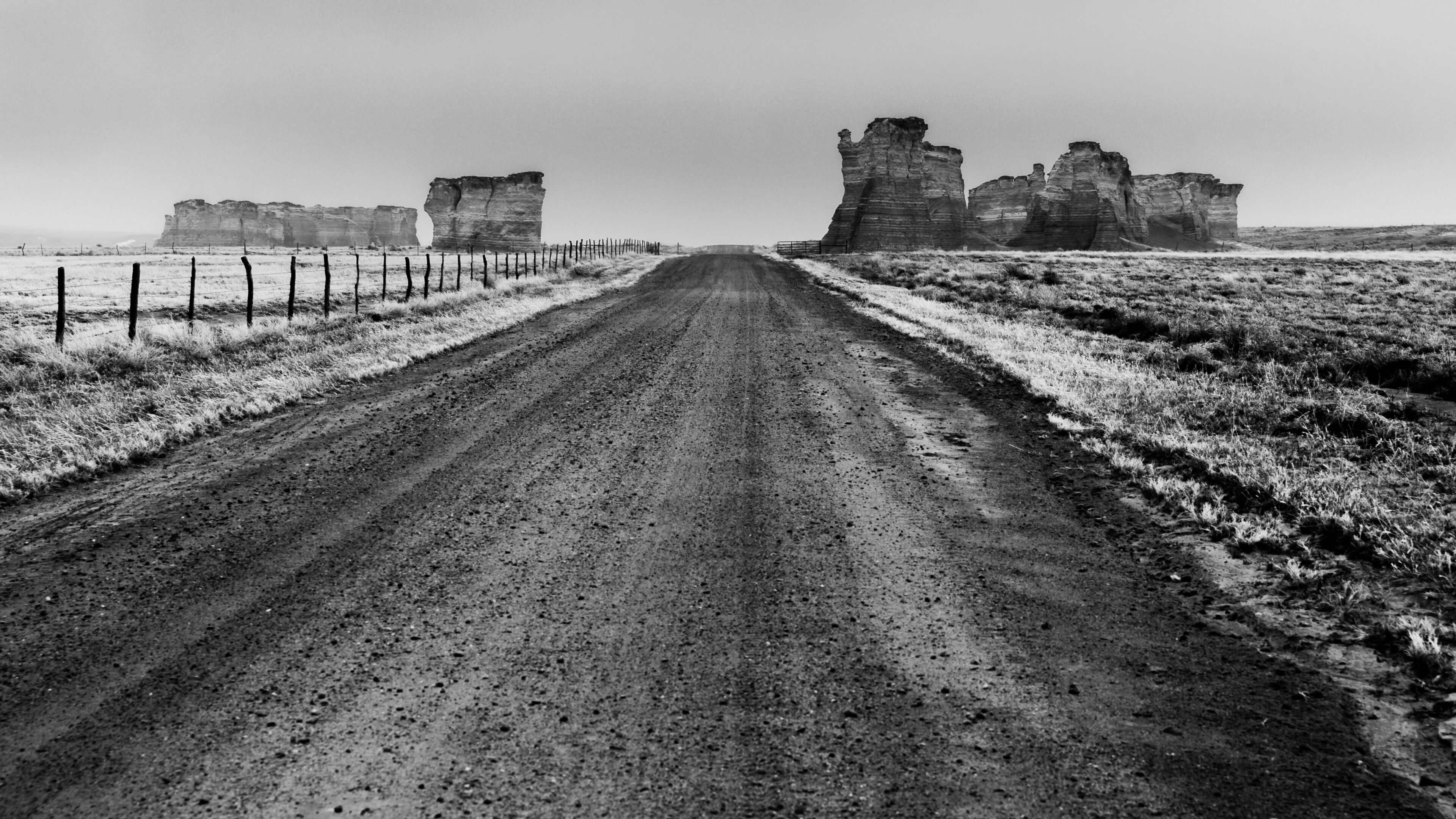 A dirt road leading to ancient stone ruins in a barren landscape.