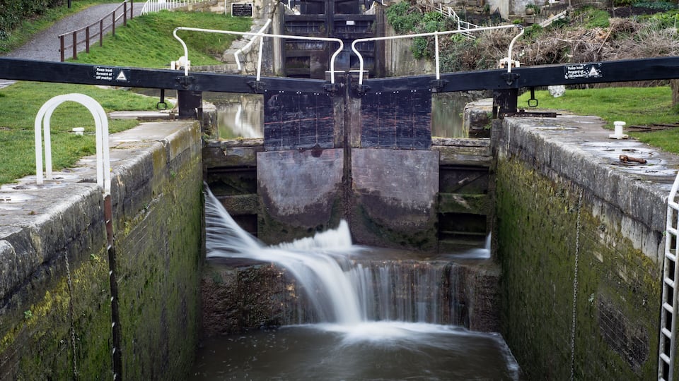 Widcombe locks on Kennet and Avon Canal. Lock with water escaping at high pressure through gaps, spilling onto cill
