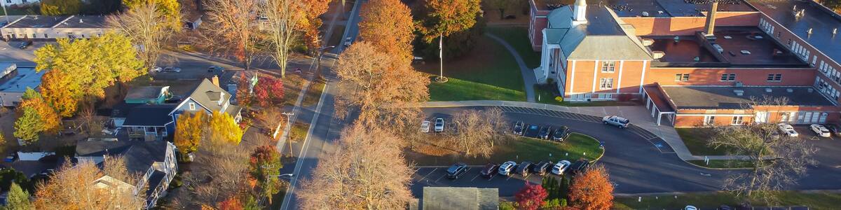 Large historic traditional Church building with large parking lots and colorful fall foliage in small town Penfield, County of Monroe, Upstate New York, USA