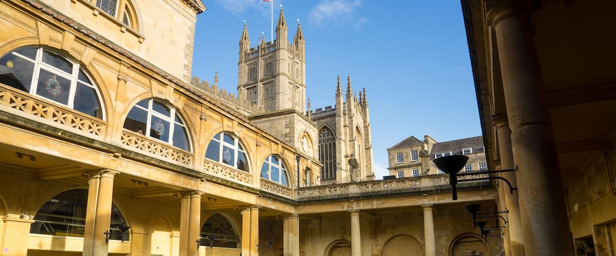 BATH, ENGLAND - NOVEMBER 22, 2014: Roman Baths with Bath Abbey i