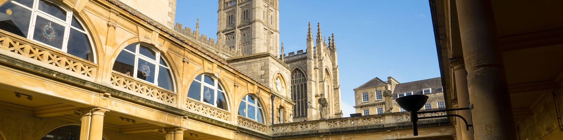 BATH, ENGLAND - NOVEMBER 22, 2014: Roman Baths with Bath Abbey i