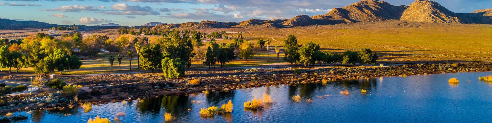 A river with yellow foliage, a mountain range, and a clear sky.