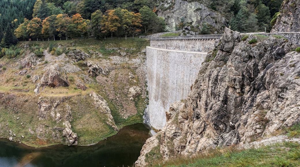 Un barrage sur une rivière qui traverse une vallée, entouré de collines boisées.