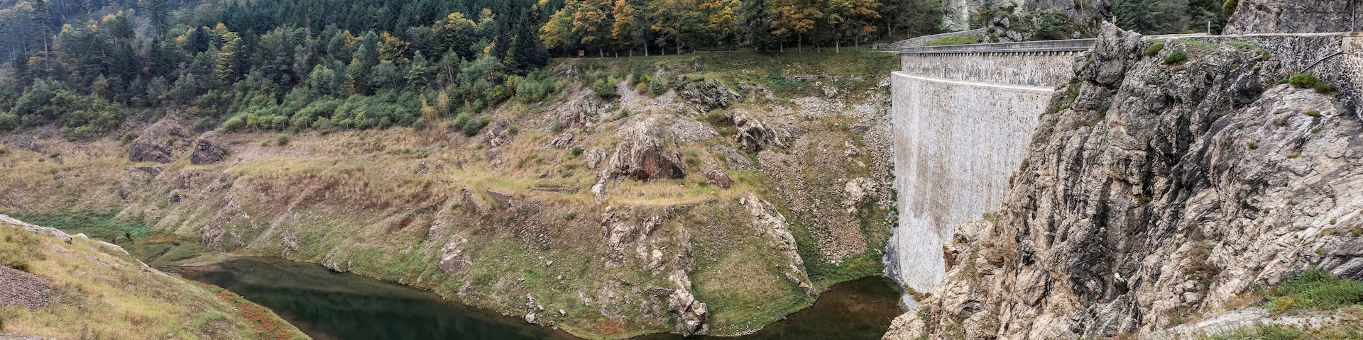 Una presa con un río que atraviesa un valle, rodeado de colinas boscosas.