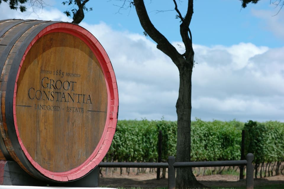 Un barril de madera con el texto "Groot Konstantia Landgoed Estate" y un árbol al fondo.