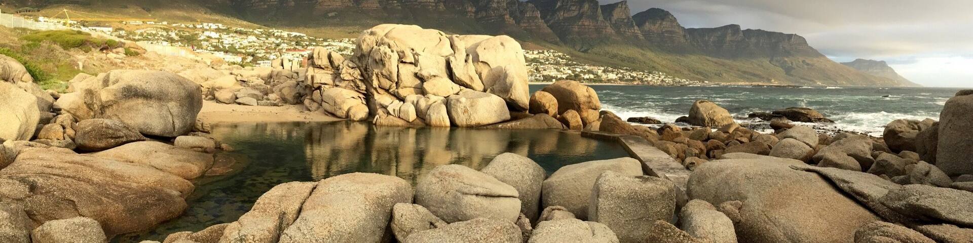 This tidal pool at the north end of Camps Bay main beach is the perfect spot to watch the sun sink while the "Table Cloth" rolls over Table Mountain National Park #GoldenHour #CampsBay #SouthAfrica #CapeTown