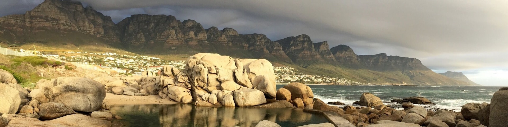This tidal pool at the north end of Camps Bay main beach is the perfect spot to watch the sun sink while the "Table Cloth" rolls over Table Mountain National Park #GoldenHour #CampsBay #SouthAfrica #CapeTown