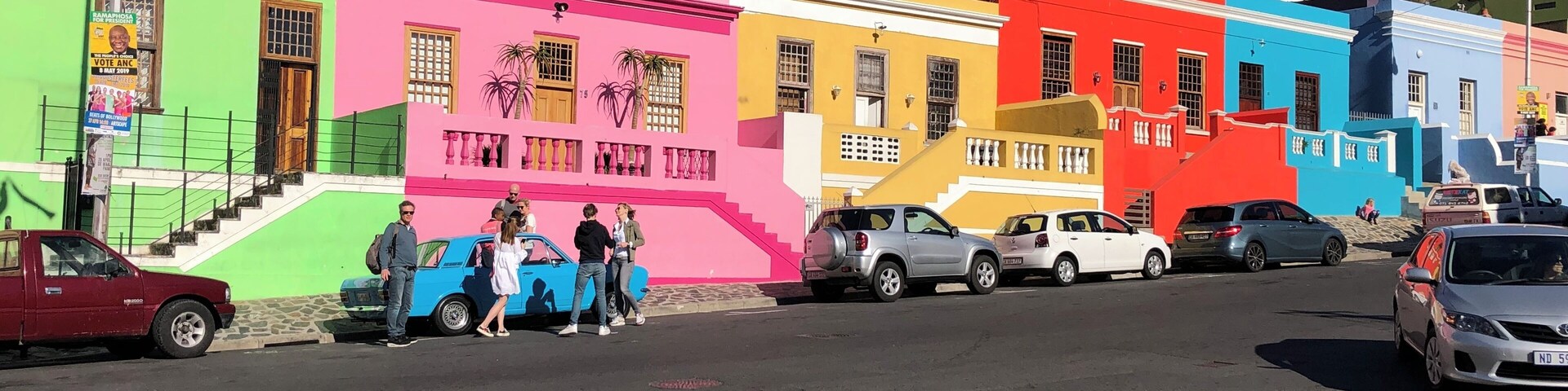 Uma rua colorida com edifícios pintados em tons de rosa, amarelo, azul e verde.