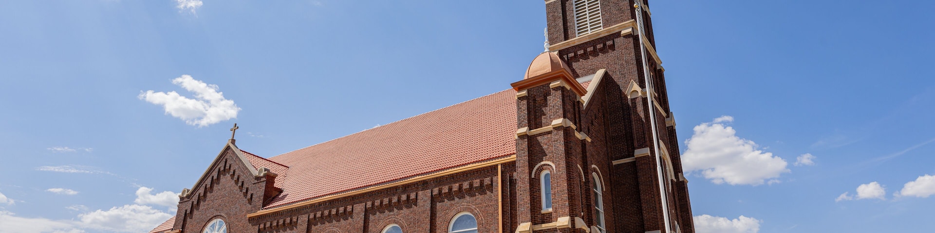 A brick church with a tall steeple and a sign reading "Saint Rose of Lima Catholic Church".