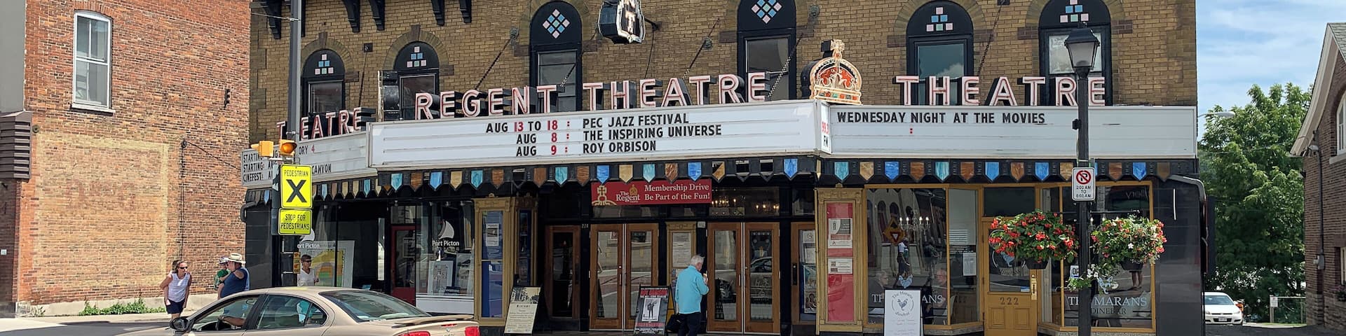 A brick theatre with a red roof and a Canadian flag.