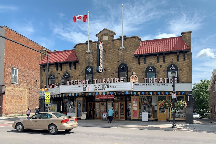 Un teatro de ladrillo con techo rojo y una bandera canadiense.